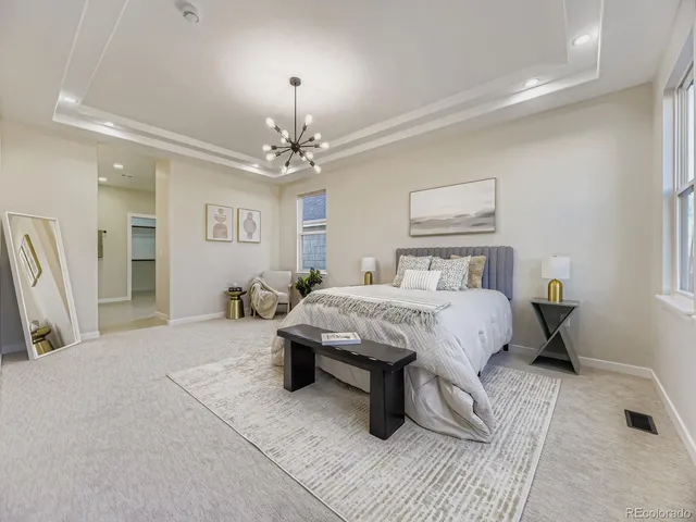 a spacious bedroom with a bed and a chandelier