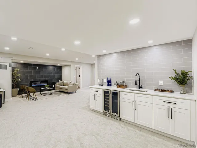 a living room with furniture a flat screen tv and kitchen view