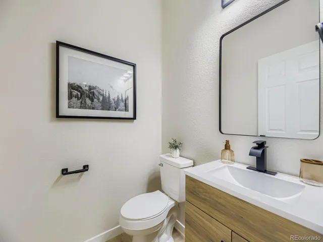 a bathroom with a toilet a sink and mirror