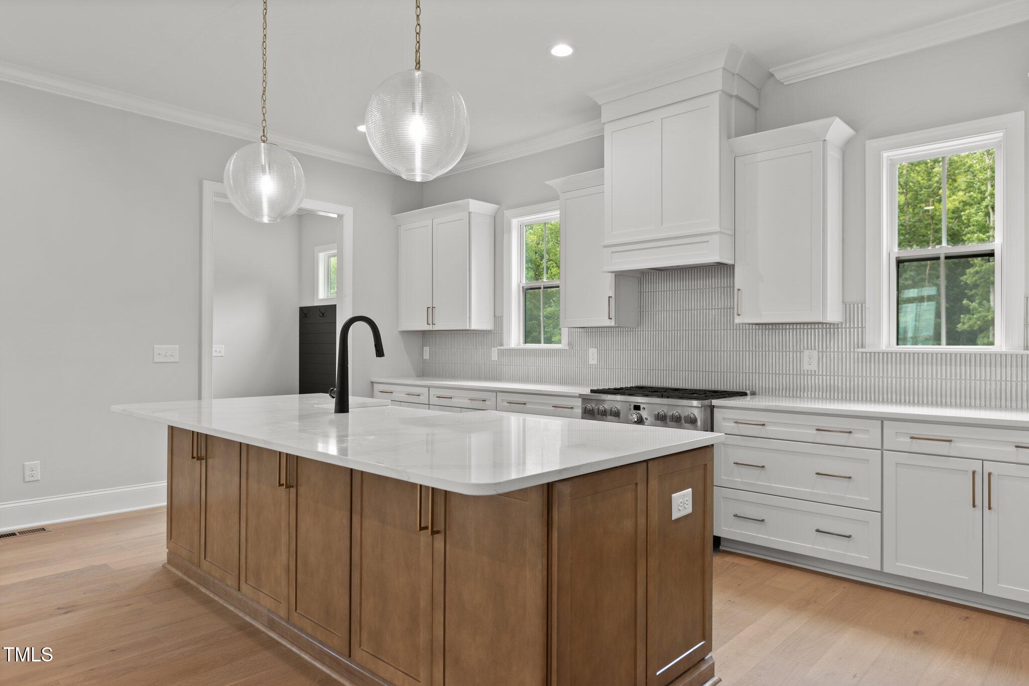 9305 Field Maple Court Raleigh, NC 27613 - Photo 2 of 13 a kitchen with kitchen island granite countertop a sink a center island a stove and a window