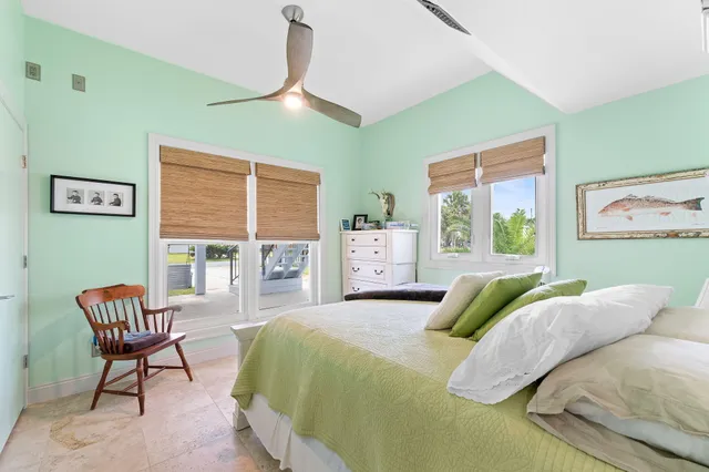 a bedroom with a bed chair and a large window