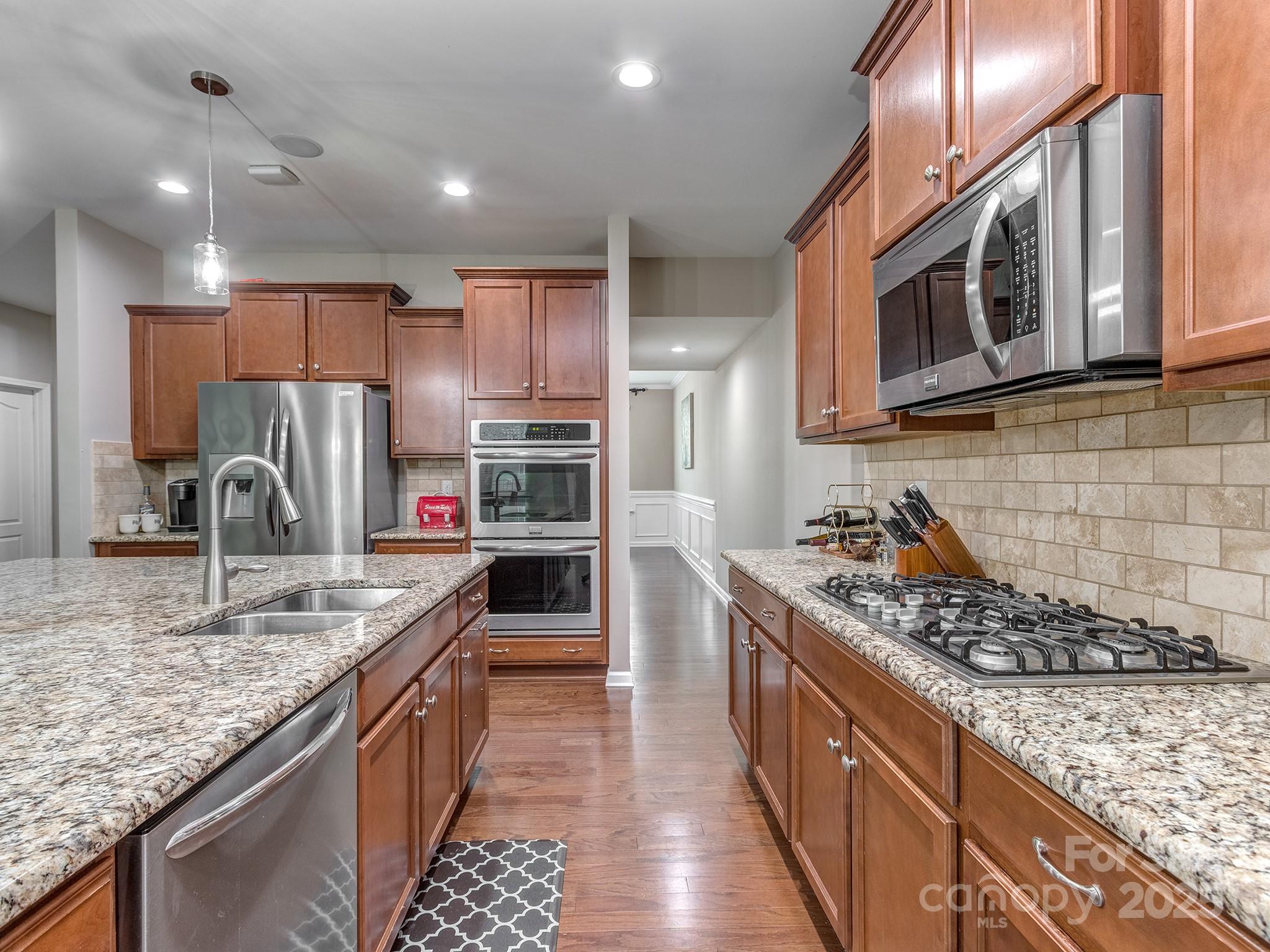 140 Halifax Drive Fort Mill, SC 29707 - Photo 11 of 38 a kitchen with stainless steel appliances granite countertop a stove top oven a sink dishwasher a refrigerator and cabinets with wooden floor