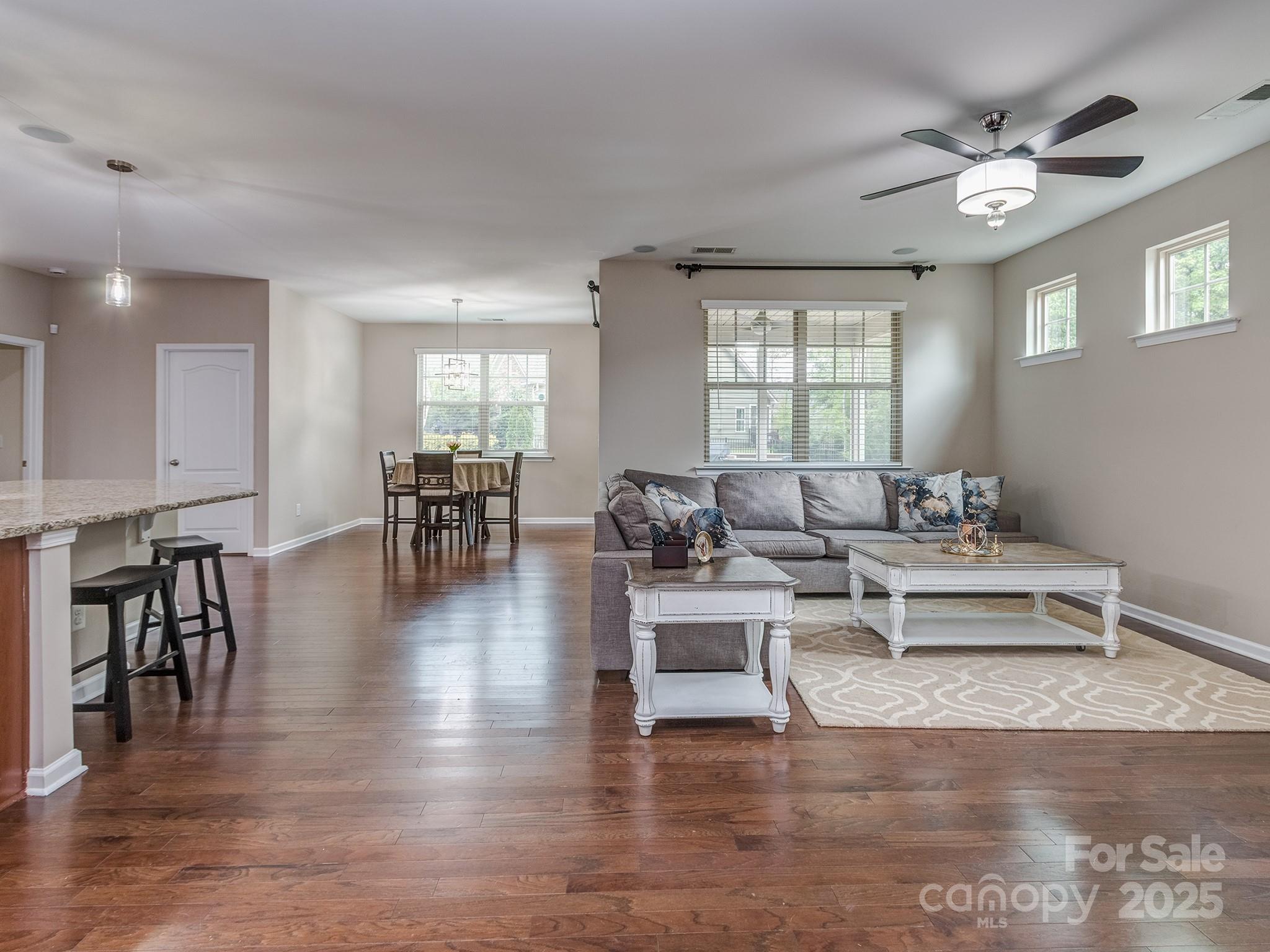 140 Halifax Drive Fort Mill, SC 29707 - Photo 7 of 38 a living room with couches a dining table and kitchen view with wooden floor