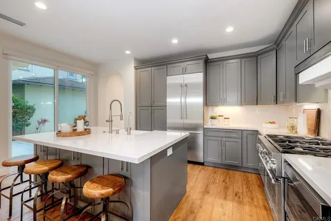 a kitchen with a table chairs and white cabinets