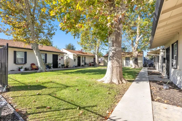 a front view of a house with a yard and trees