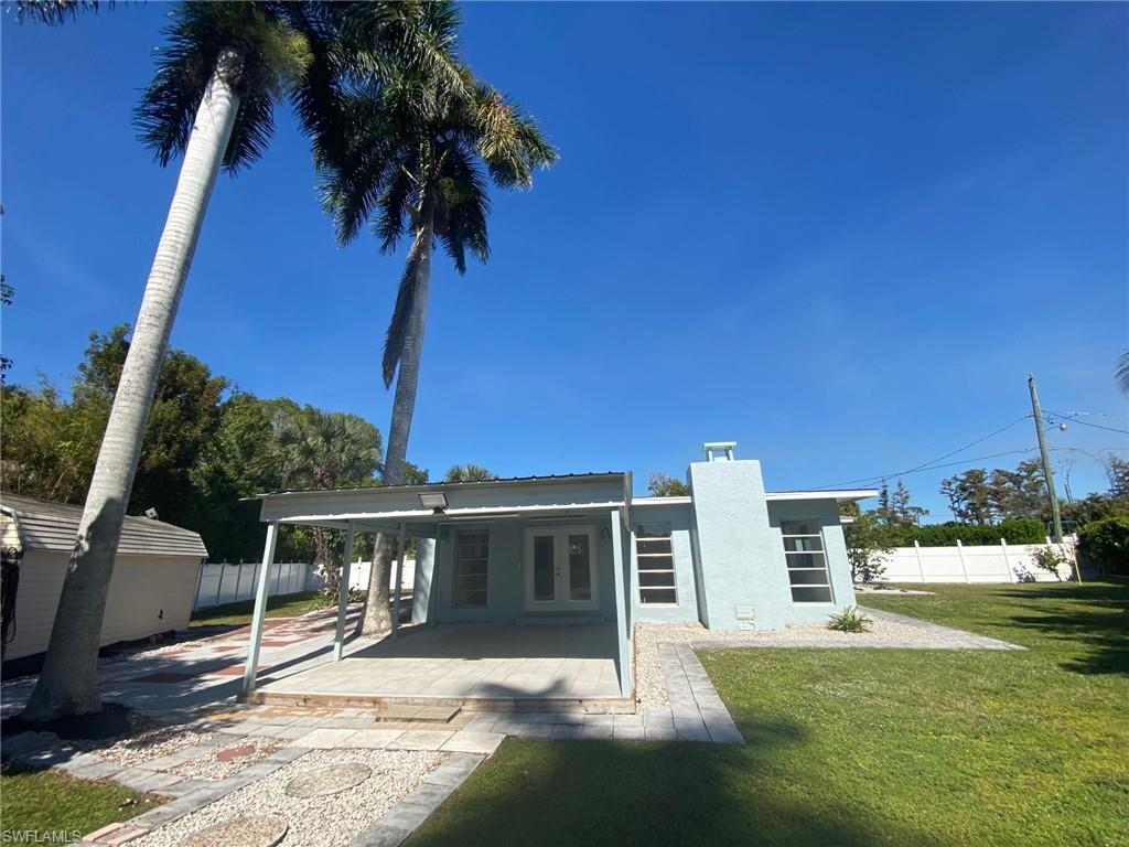 22 Constitution Drive Naples, FL 34112 - Photo 11 of 30 a front view of a house with a yard table and chairs