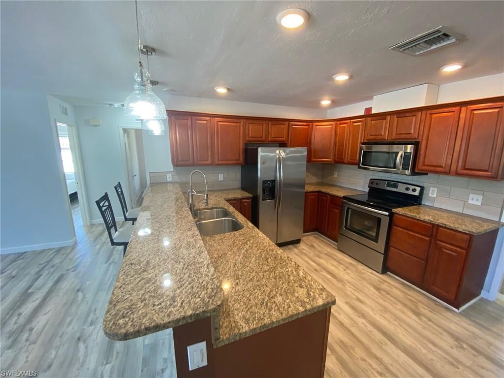 22 Constitution Drive Naples, FL 34112 - Photo 20 of 30 a kitchen with stainless steel appliances granite countertop a sink refrigerator and microwave