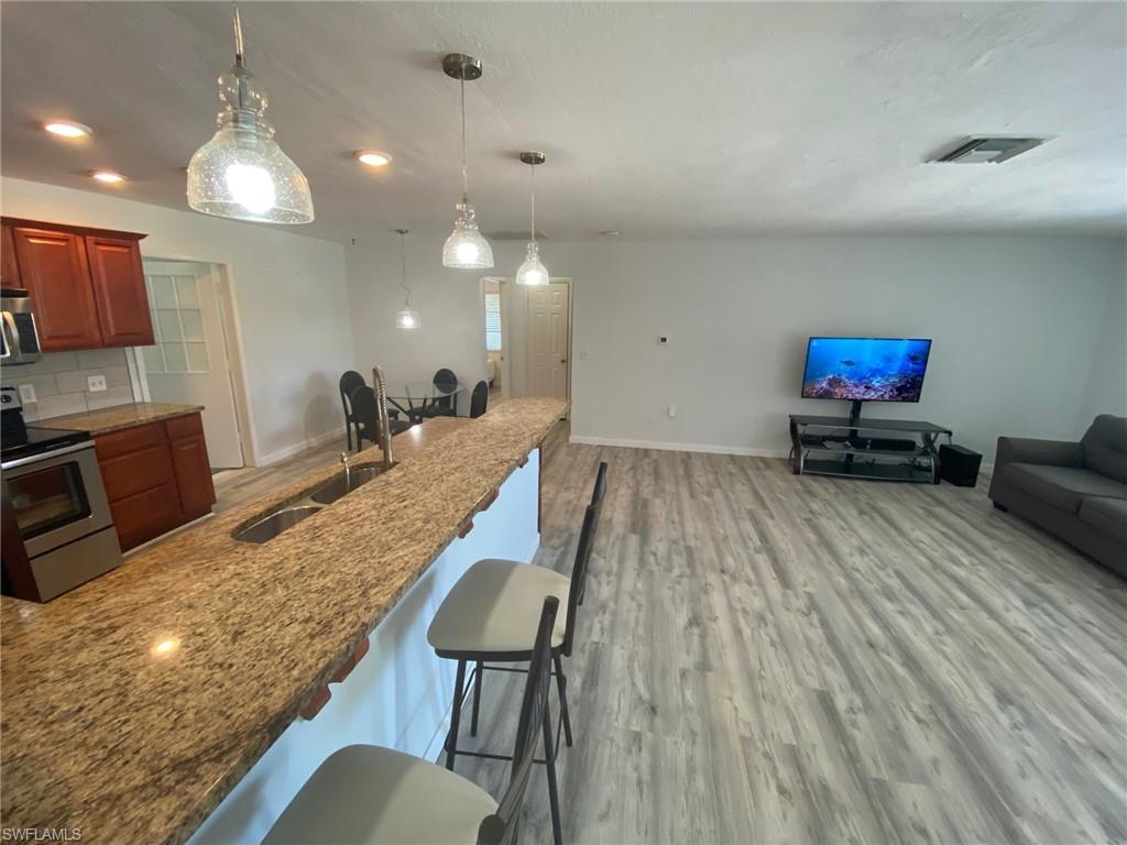 22 Constitution Drive Naples, FL 34112 - Photo 34 of 34 a living room with furniture and a wooden floor
