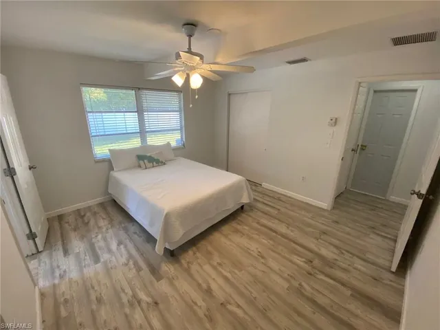 a white bed sitting in a room next to a window