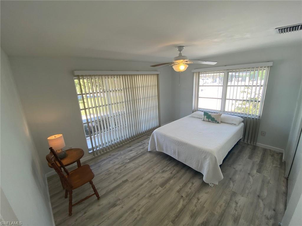 22 Constitution Drive Naples, FL 34112 - Photo 24 of 30 a bedroom with a bed and a chandelier