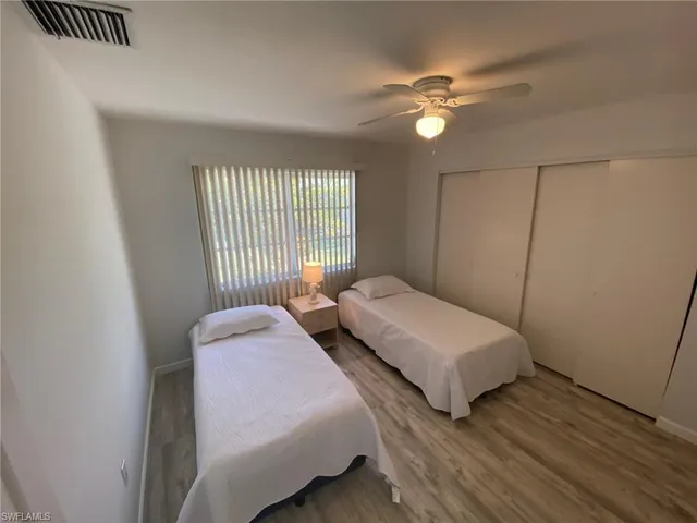 a bedroom with two beds and a chandelier
