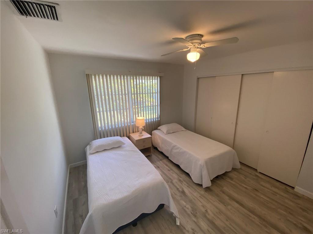 22 Constitution Drive Naples, FL 34112 - Photo 27 of 34 a bedroom with two beds and a chandelier
