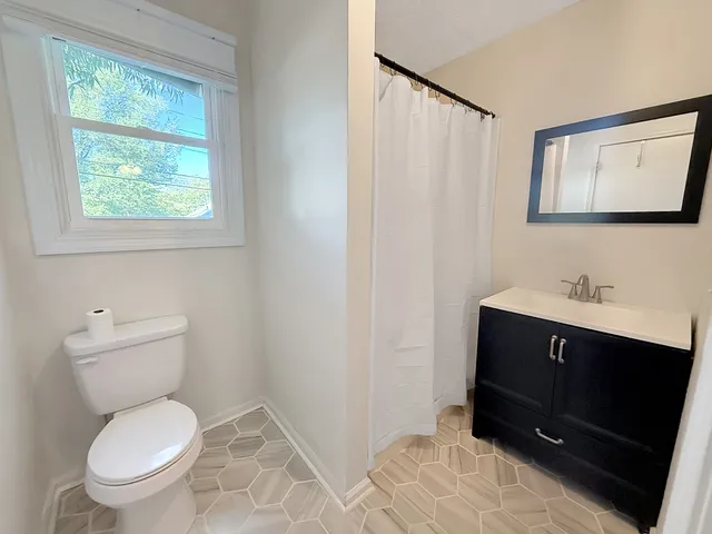 a bathroom with a toilet sink and mirror