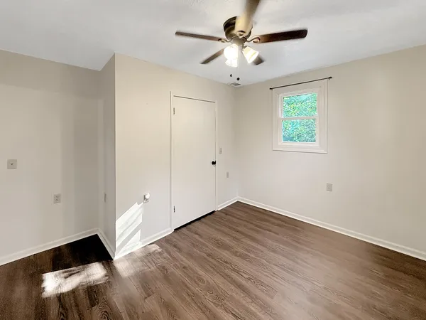 an empty room with wooden floor and window