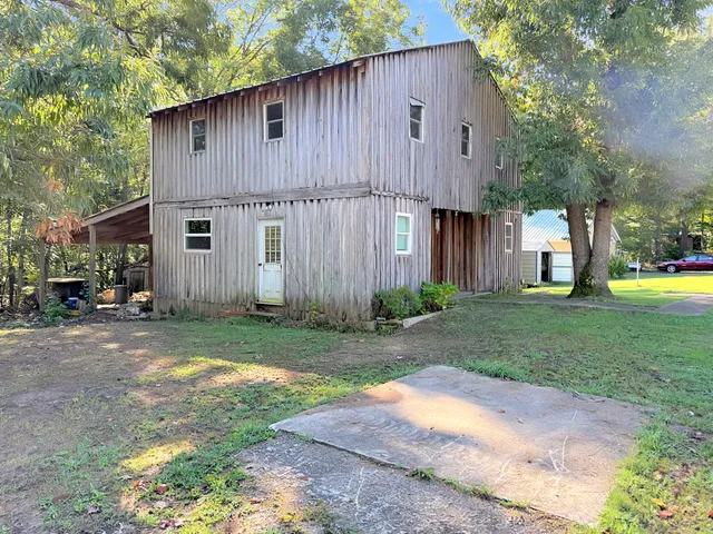 a view of a house with backyard and a tree