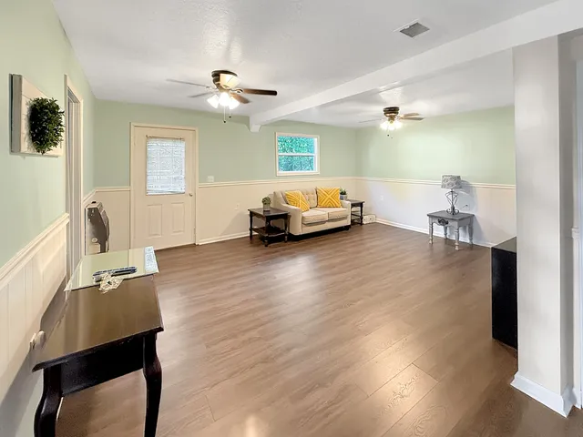 a living room with furniture and a wooden floor
