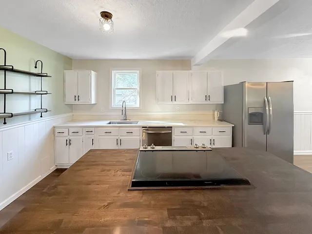 a kitchen with stainless steel appliances a refrigerator sink and cabinets