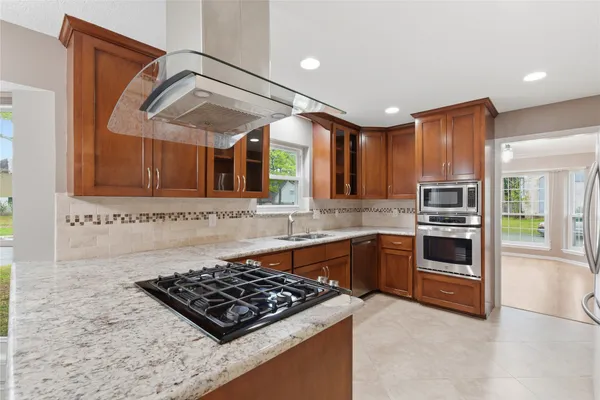 a kitchen with stainless steel appliances granite countertop a refrigerator and a stove