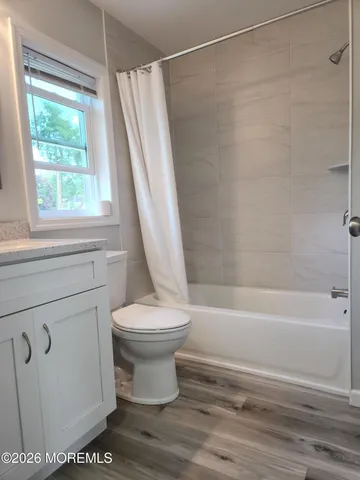 a bathroom with a shower a toilet and a tub