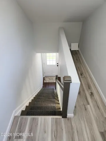 a view of entryway and hall with wooden floor