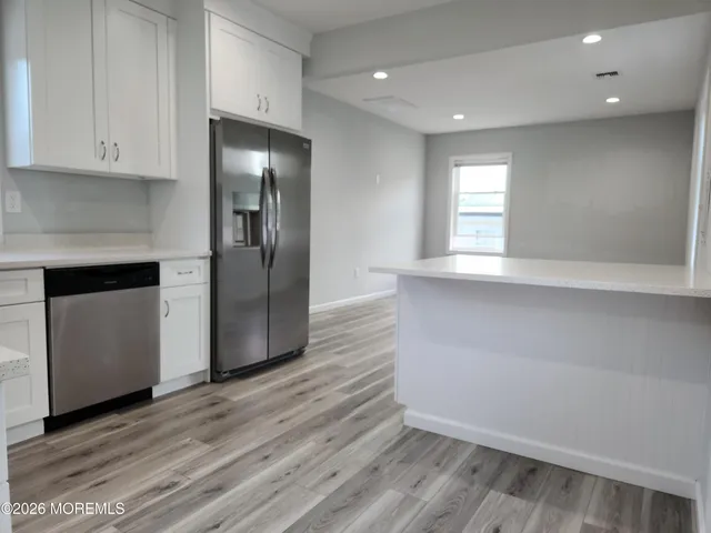 a view of a kitchen with a sink and a refrigerator