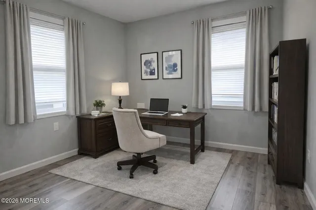 a workspace with wooden floor and a window