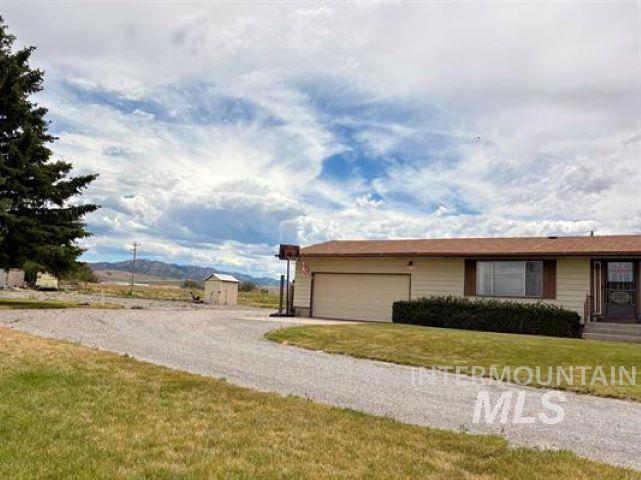 3197 Neeley Road American Falls, ID 83211 - Photo 2 of 45 Ranch-style residence featuring a gravel driveway, attached garage, and a peaked roof