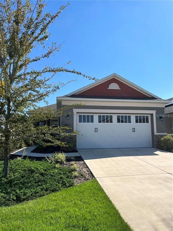 9879 Southwest 99th Loop Ocala, FL 34481 - Photo 1 of 12 a front view of a house with a garden