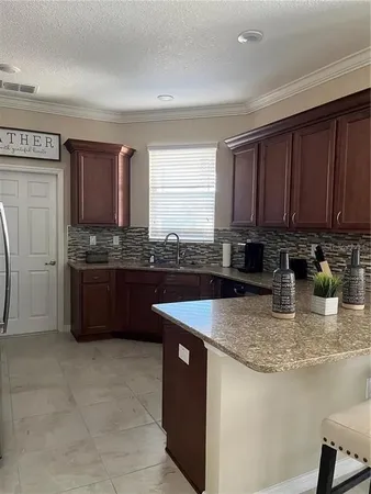 a kitchen with granite countertop a sink and cabinets