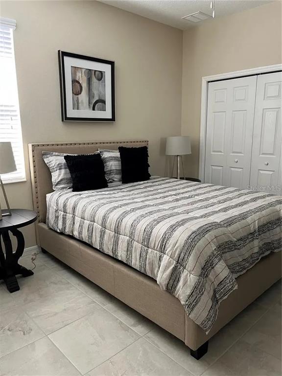 9879 Southwest 99th Loop Ocala, FL 34481 - Photo 7 of 12 a bedroom with a bed and painting on the wall