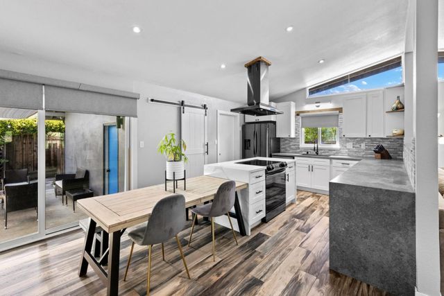 a kitchen with a table chairs refrigerator and microwave