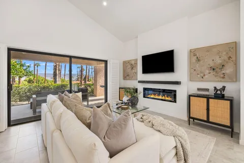 a living room with furniture a fireplace and a flat screen tv