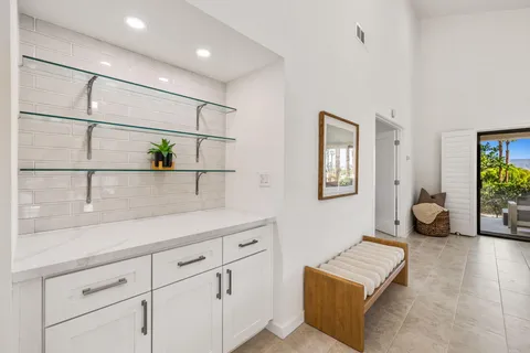 a hallway with a couch a chandelier and a window