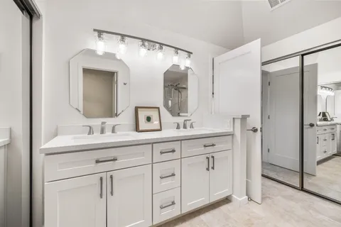 a bathroom with a double vanity sink and mirror