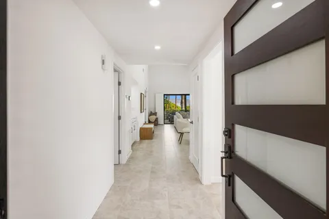 a view of a hallway with wooden floor and a living room