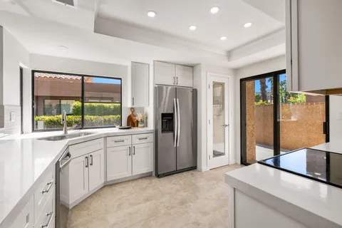 a kitchen with stainless steel appliances granite countertop a refrigerator and a sink