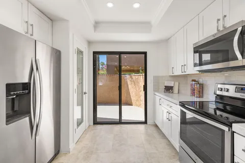 a kitchen with stainless steel appliances granite countertop a refrigerator a stove and a sink