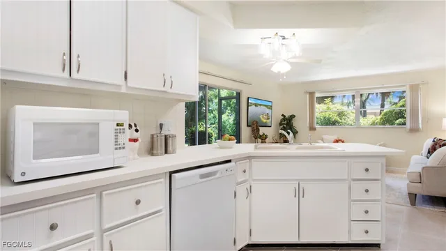 a kitchen with cabinets stainless steel appliances a sink and a window