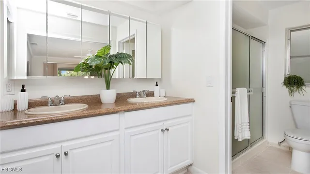 a en suite bathroom with a granite countertop sink and a mirror