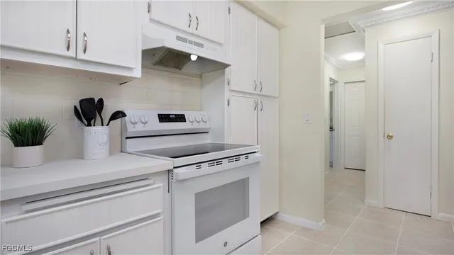 a kitchen with white cabinets and appliances