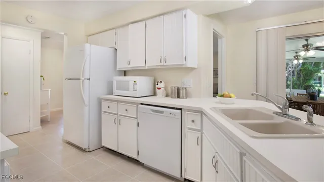a kitchen with white cabinets sink and refrigerator