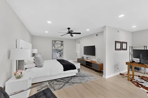 a bedroom with a bed and a flat screen tv