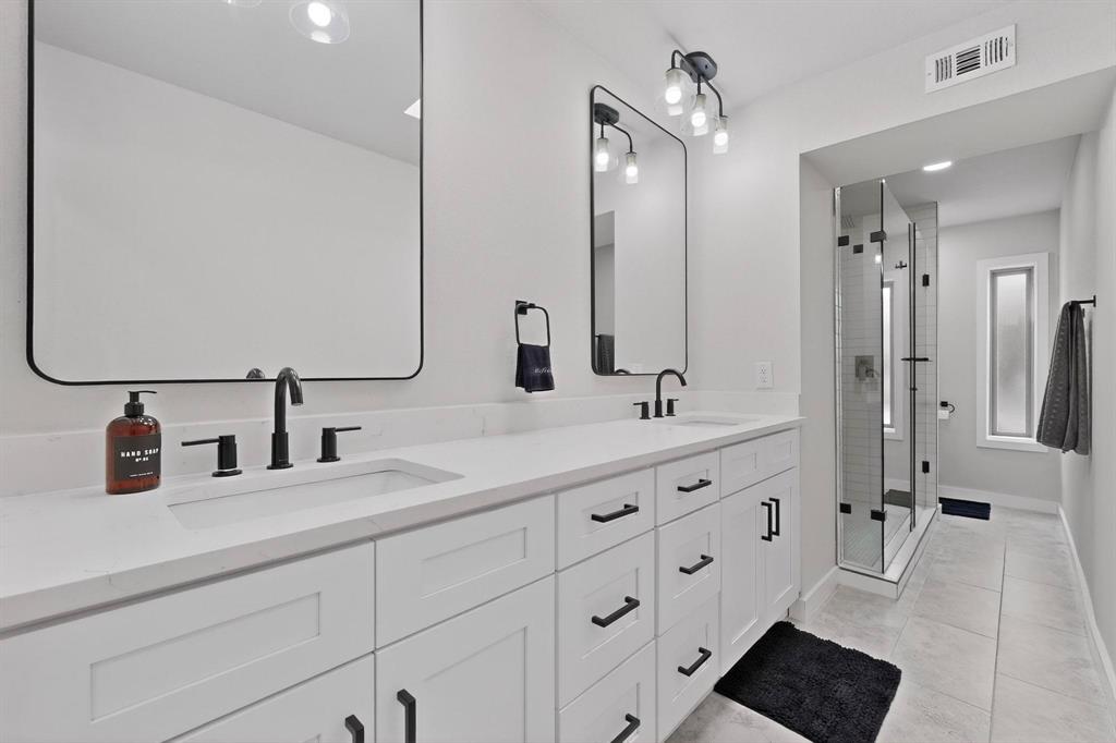5015 Thunder Road Dallas, TX 75244 - Photo 16 of 31 a bathroom with double vanity sink a mirror and shower