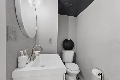 a white toilet sitting next to a bathroom sink