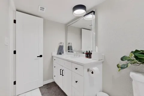a bathroom with a sink a toilet and a mirror