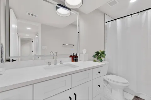 a bathroom with a sink toilet and a mirror