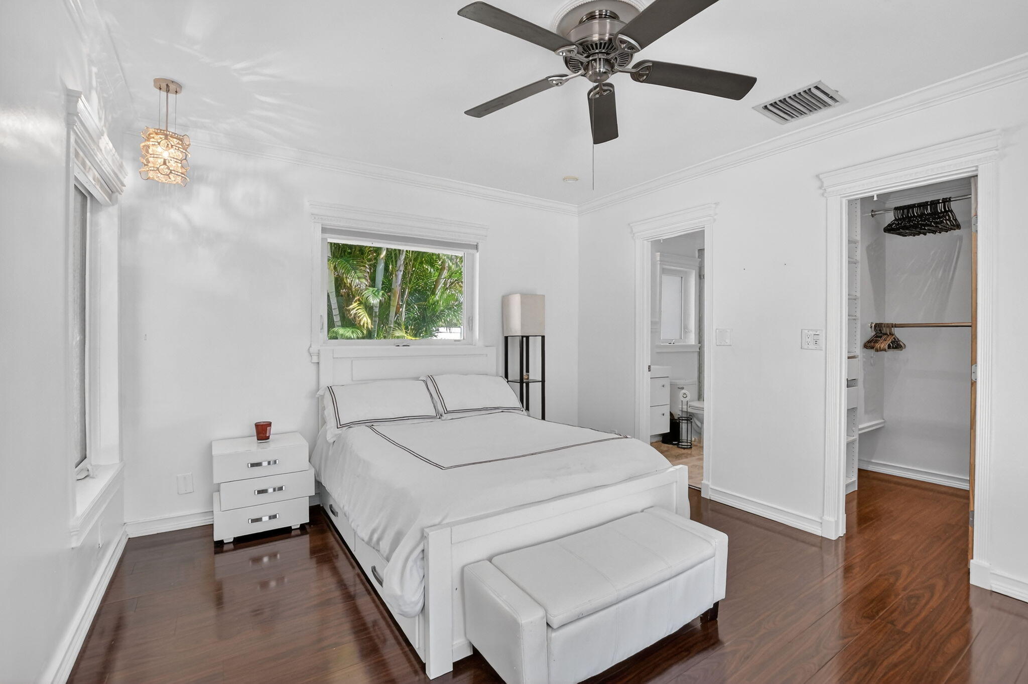1455 Isabel Road East Boca Raton, FL 33486 - Photo 12 of 33 a bedroom with a bed and a chandelier