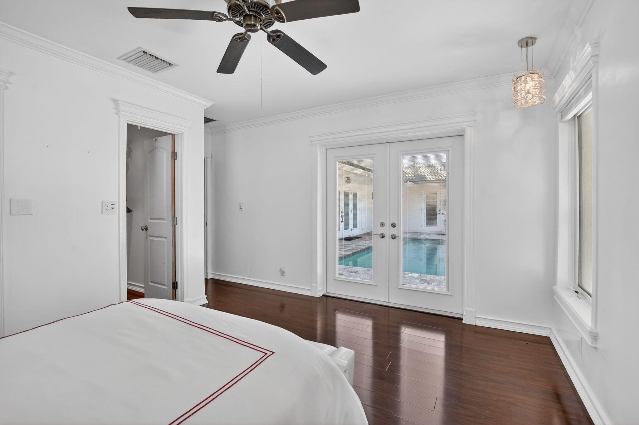 1455 Isabel Road East Boca Raton, FL 33486 - Photo 13 of 33 a bedroom with a bed and a chandelier