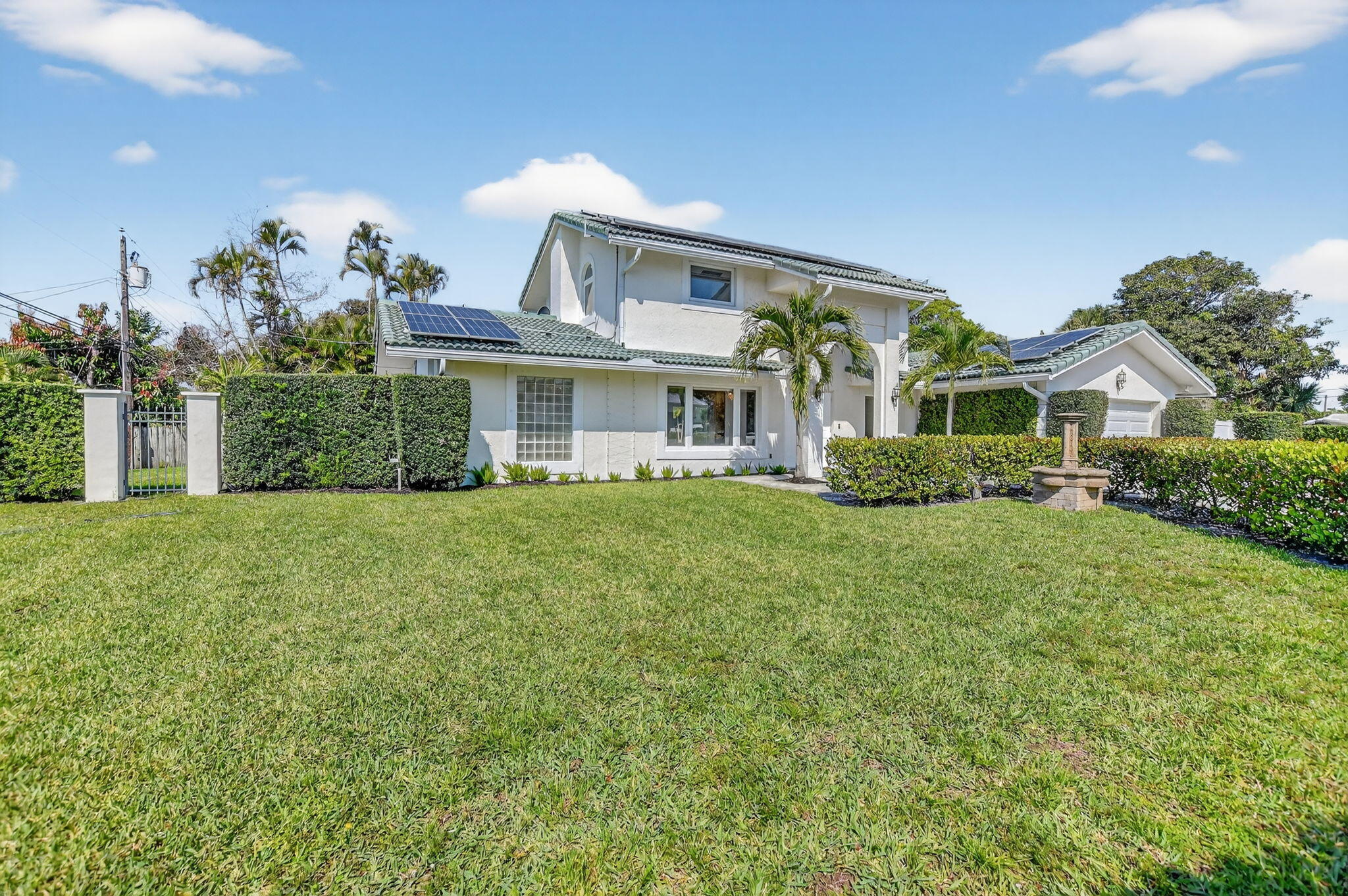 1455 Isabel Road East Boca Raton, FL 33486 - Photo 2 of 33 a front view of a house with a garden