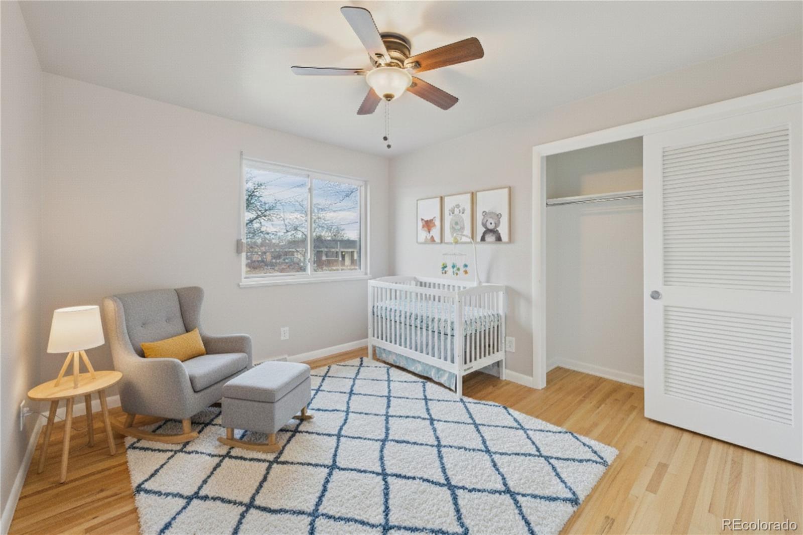 6085 Simms Street Arvada, CO 80004 - Photo 12 of 32 a living room with a baby crib furniture and a chandelier